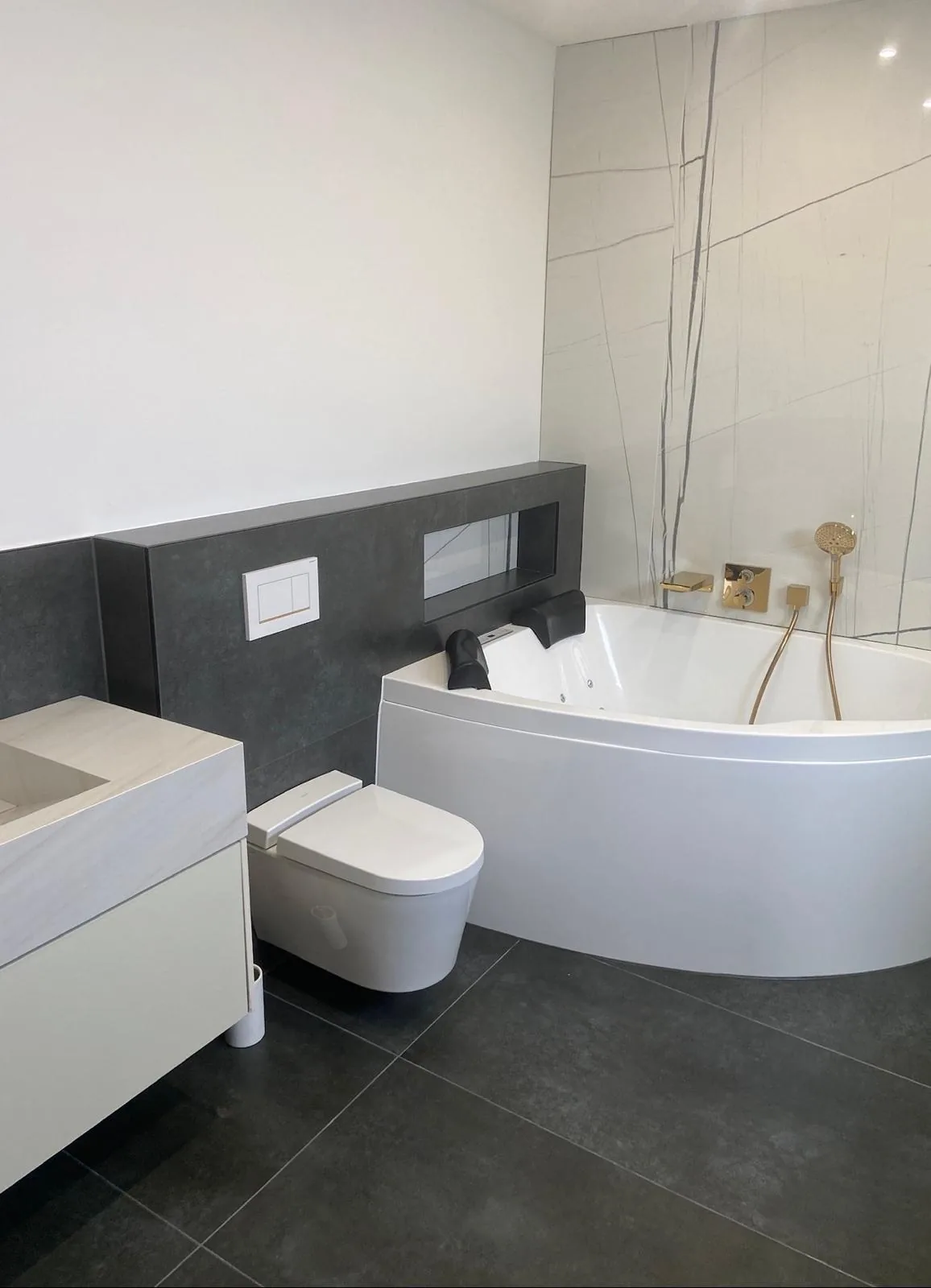 Badezimmer mit Eckbadewanne und Großformatfliesen — Fliesen Gottschald